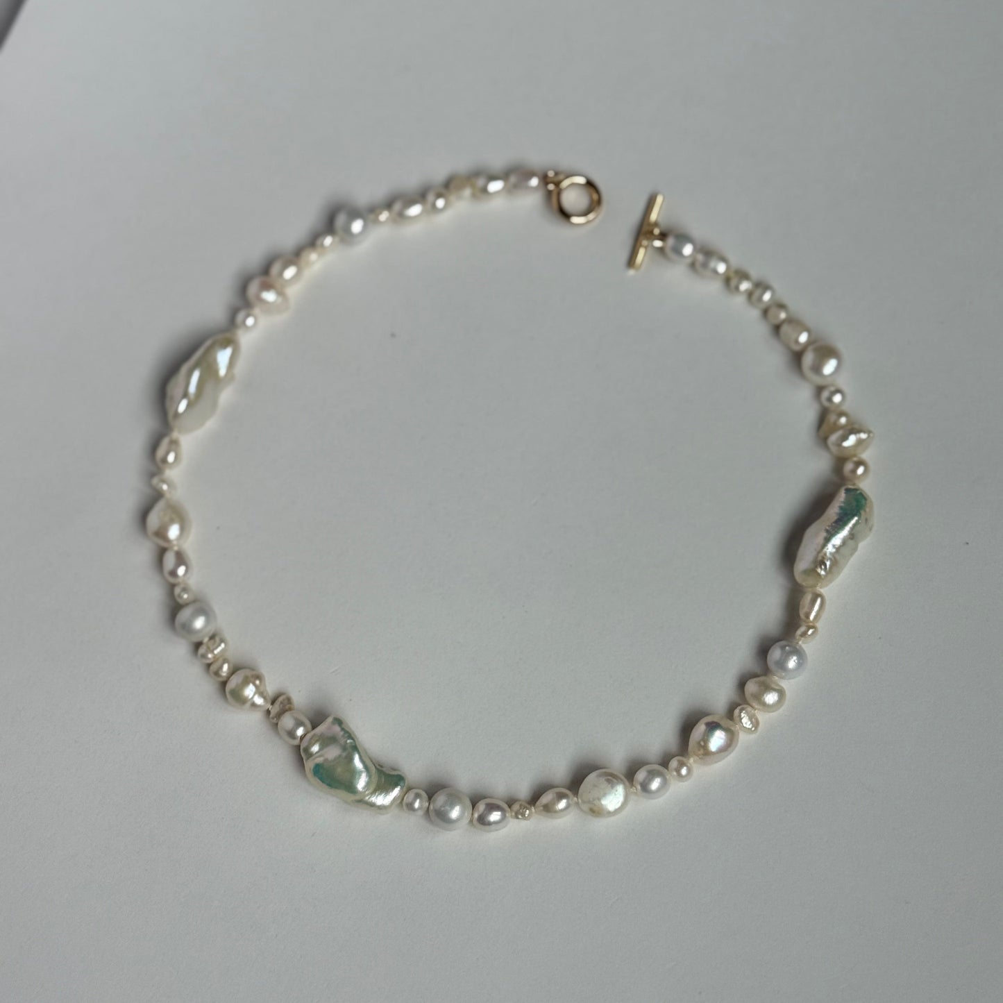 Pearl necklace on a light gray surface