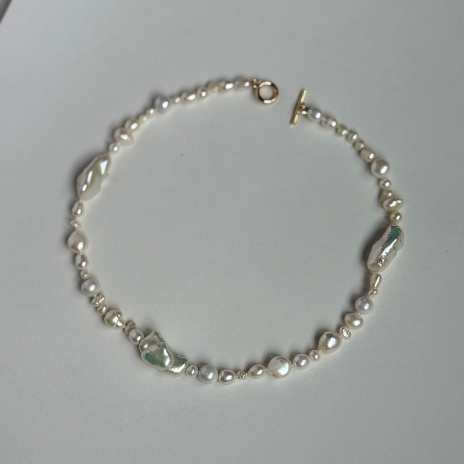Pearl necklace on a light gray surface