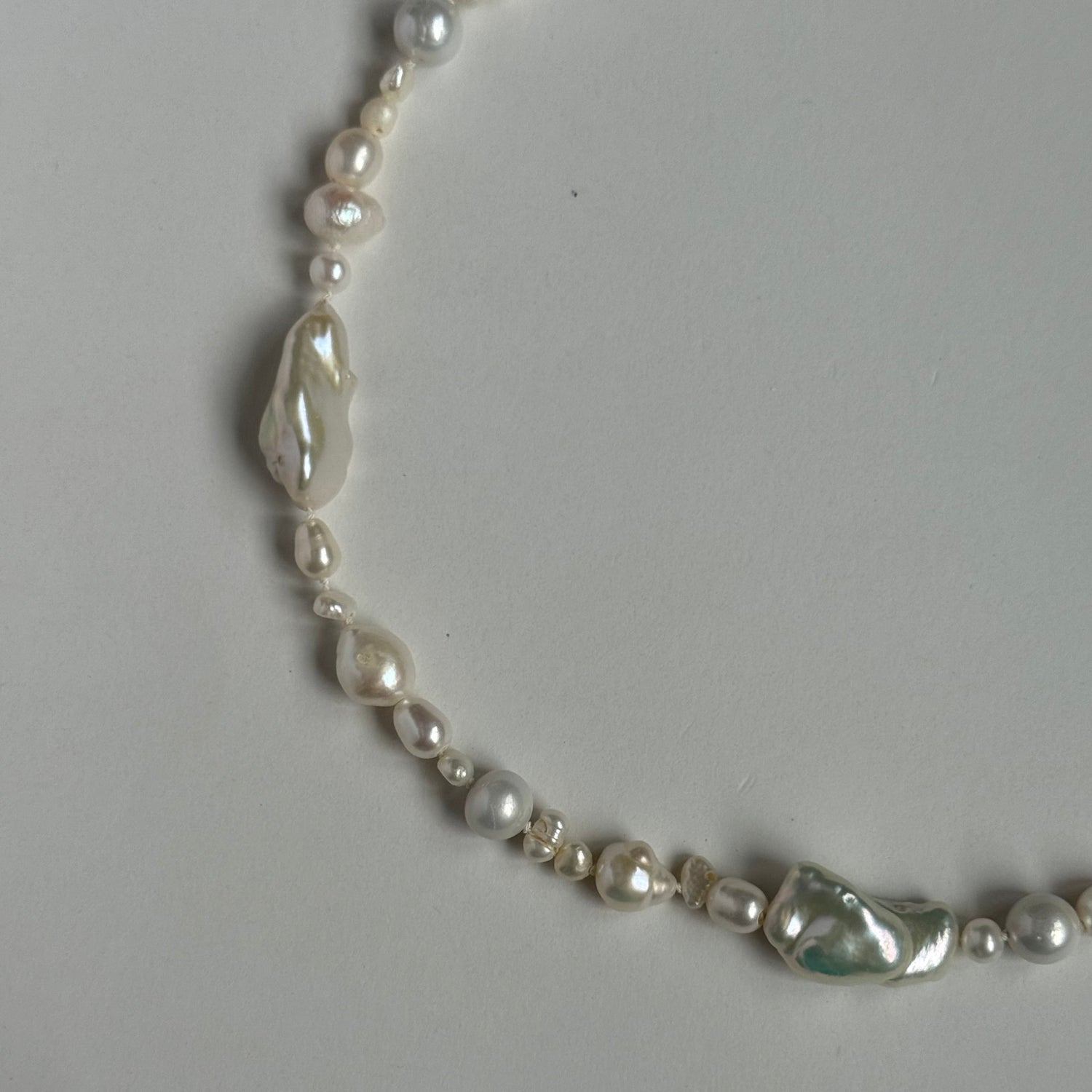 Pearl necklace on a light gray background