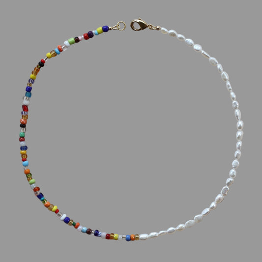 A colorful beaded necklace with freshwater pearls and a 14k gold plated clasp, displayed on a neutral background.